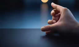 a person has their hand resting on a table