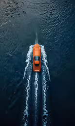 an orange motor boat speeds through the water