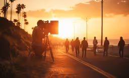 a video camera is positioned for a picture of people at sunset