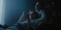two women sit on the couch and stare at each other