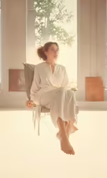 a person with red hair and eyeshades is sitting on a chair