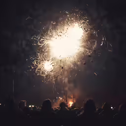 several people are watching fireworks with big smoke