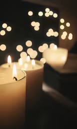 three candles lit in front of an abstract background