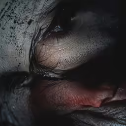 an open eyed woman in wet makeup with a black background