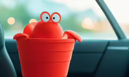a little red pot with a face sitting inside