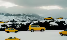 a snow covered field with cars parked in it