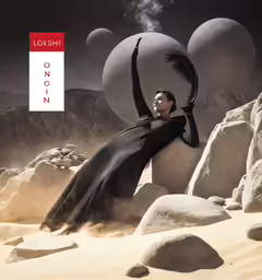 a woman wearing black is sitting on a rock and rocks