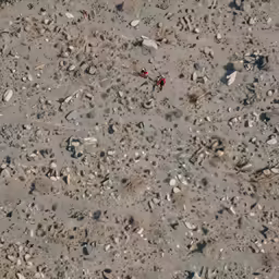two people walking through some rocks and gravel