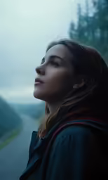 the girl is looking into the distance with a scenic view