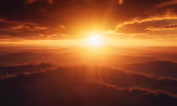 the sun setting in the background with clouds above the horizon