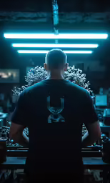 a man in a black shirt is standing at a bar