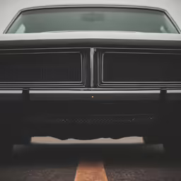 an old, black car sits in a parking lot