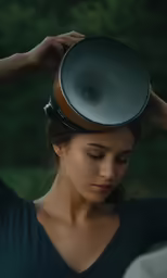 a woman standing outside holding a megaphone up to her head