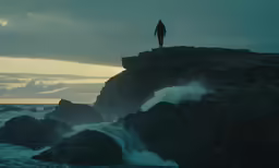 a person standing on top of rocks overlooking the ocean