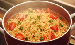 a pot filled with noodles and tomatoes on top of a table