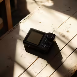 a black camera is sitting on a wood table