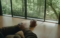 a person is sitting on the floor in front of a window