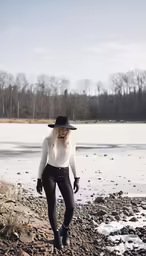 a woman standing on top of a rocky field