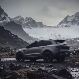 a large suv sits in the middle of the mountains