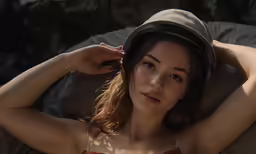 a young woman poses for a picture while wearing a hat