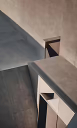 a cement wall with white drawers next to it