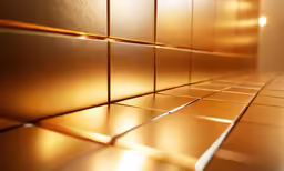 close up view of a tiled wall with golden colors