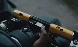 a hand holding a camera over the handle bars