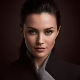 a woman poses for a professional portrait with black background