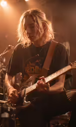 a man playing an electric guitar in front of a microphone