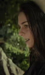 a woman with long hair is sitting outside
