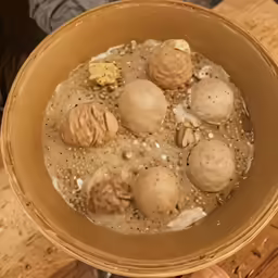 a person holding a bowl with food inside it