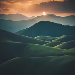 sunset over mountains with rolling hills and trees