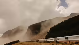 the clouds are low in the mountains as train passes by