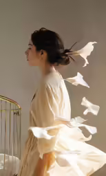 a woman in a dress with birdcage flying behind her
