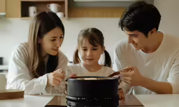 a family eats rice inside of the kitchen