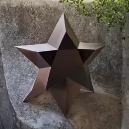 a sculpture of a star sitting on top of a cement block
