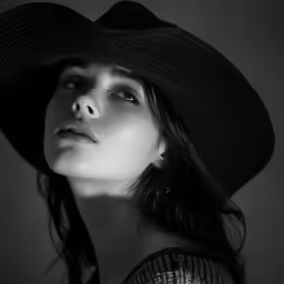 a black and white photo of a woman with a hat