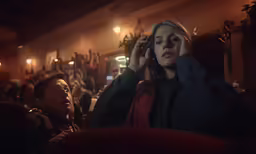 woman covering her eyes sitting in audience