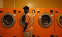 a man standing in front of the laundry machine