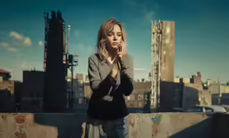 woman holding cigarette standing in urban city