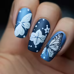 nail art featuring butterfly designs on blue background