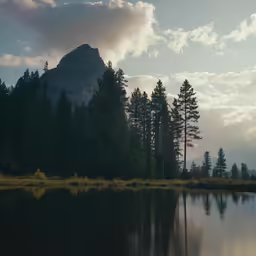 the mountain is reflected in the water near some trees