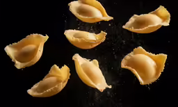 small shells are sprinkled with water on a black background