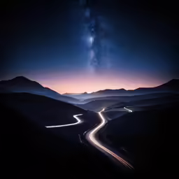 the view of a mountain and road with a galaxy in the background