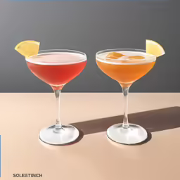two colorful beverages are sitting on the table