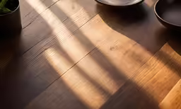 a wooden table topped with a plate and cup