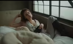 there is a beautiful woman laying in bed