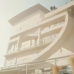 a building that has a balcony and people standing on it