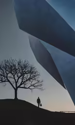 silhouette of man standing beneath huge building in winter