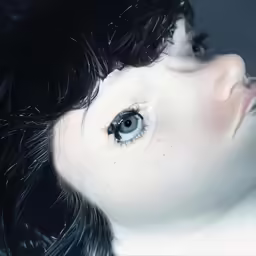 the eyes of a young woman with a curly style